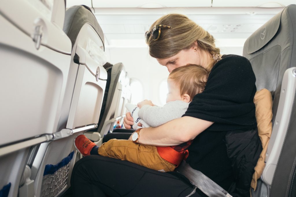 donna in aereo con neonato